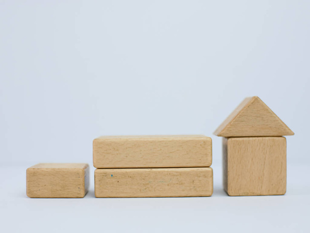 escadas feitas de cubos de madeira com uma casa no topo. investimento seguro e compra de casa conceito imobiliário hipotecário - Foto, Imagem