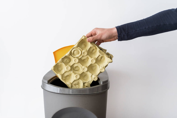 Viljelty näkymä henkilö heittää paperia roskakoriin. Jätteiden kierrätys. Pelastaa planeetta. Ympäristönhoidon käsite. Ekologinen elämäntapa. Roskien lajitteluprosessi - Valokuva, kuva