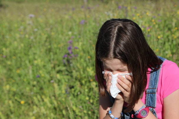 young girl blowing her nose for cold due to pollen allergy - Photo, Image