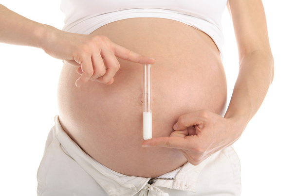 Pregnant woman holding a test tube with sperm - Valokuva, kuva