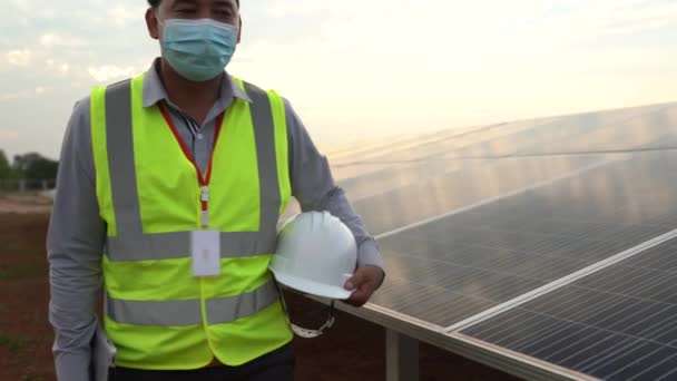 Záběry následují inženýry držící helmy, kteří kontrolují solární panely pro výrobu solární energie - Záběry, video