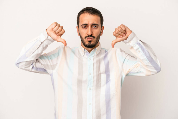Young caucasian man isolated on white background showing a dislike gesture, thumbs down. Disagreement concept. - Photo, Image