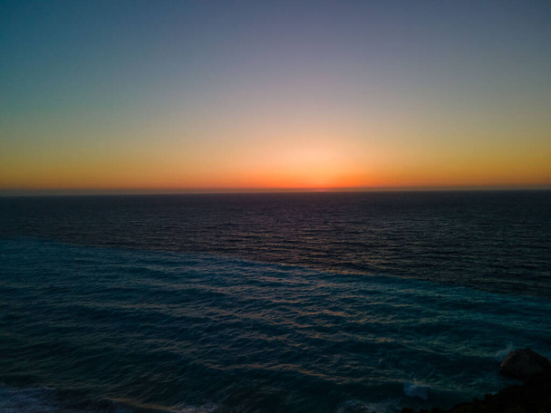 海の地平線の太陽のディスクカラフルな夕日のコピースペース - 写真・画像