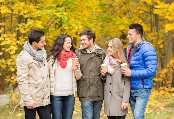 group of smiling friend with coffee cups in park - Zdjęcie, obraz