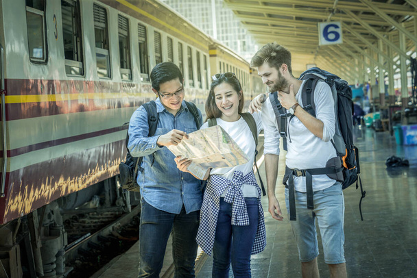 Πολυεθνικοί ταξιδιώτες κοιτάζουν το χάρτη στο σιδηροδρομικό σταθμό, ταξιδιωτική και μεταφορική έννοια - Φωτογραφία, εικόνα