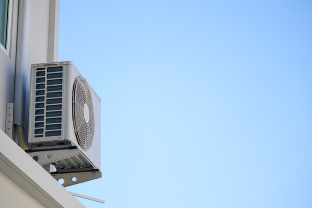 Açık hava ünitesi kompresörü evin dışına mavi gökyüzü ile kuruluyor. - Fotoğraf, Görsel