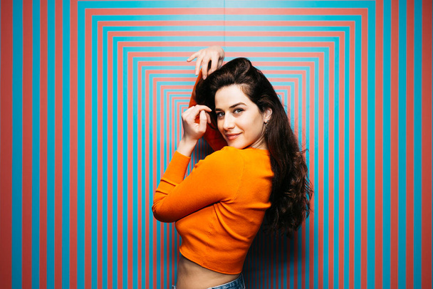 Portrait of brunette caucasian young woman with long hair, against a psychedelic background - Photo, Image
