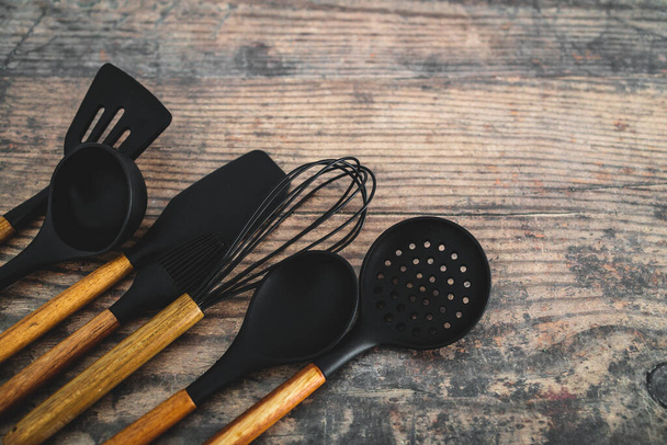set of matching wooden and silicone kitchen utensils, concept of cooking meals at home or learning to cook - Photo, image