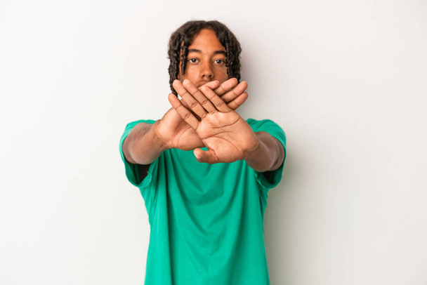 Giovane uomo afroamericano isolato su sfondo bianco facendo un gesto di negazione - Foto, immagini