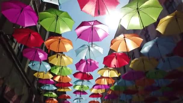 guarda-chuva multicolorido pendurado na rua em um dia ensolarado - Filmagem, Vídeo