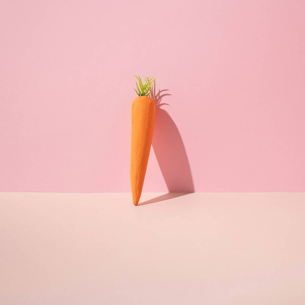 Овощной узор с искусственной апельсиновой морковью из пенопласта на синем фоне. - Фото, изображение
