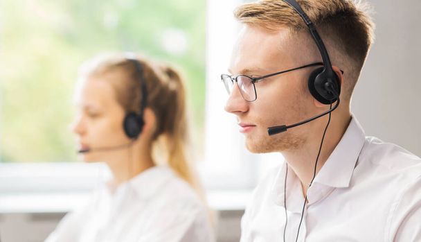Team of professional support staff working in the office. Colleagues in the workplace solve customer problems. Call center and customer support concept. - 写真・画像