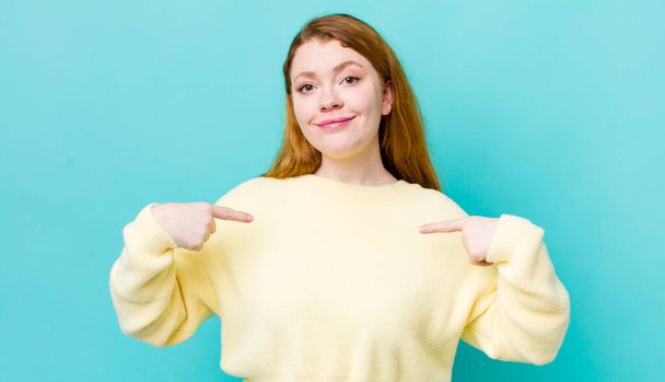 pretty red head woman looking proud, positive and casual pointing to chest with both hands - Фото, изображение
