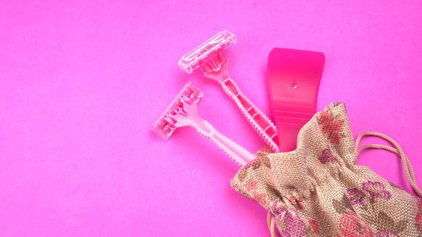 Vrouwelijke roze scheermesjes op roze achtergrond - Foto, afbeelding