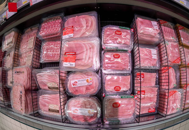 イタリア- 2022年3月30日:イタリアのスーパーマーケット、トップビュー、魚の目のビジョンで販売のための冷蔵カウンターでサラミとプロシットスライス肉の食品プラスチックパック - 写真・画像