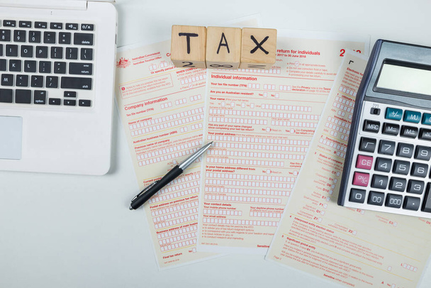 Formulários fiscais australianos com calculadora e laptop. carga fiscal. documento financeiro - Foto, Imagem