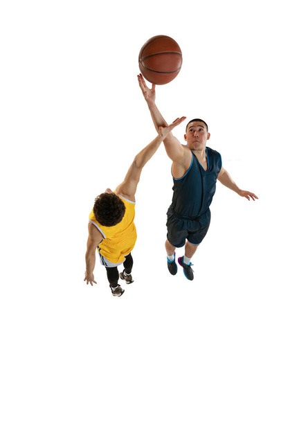 Top view of two young basketball players training with ball isolated on white studio background. Motion, activity, sport concepts. - Fotografie, Obrázek