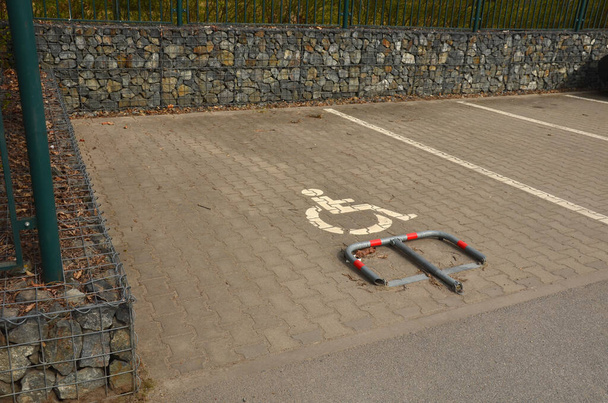 парковка для автомобилей и инвалидных колясок с механической защелкой на замке. Просто установите столб и никто не будет парковаться на месте. частный земельный участок перед многоквартирным домом - Фото, изображение