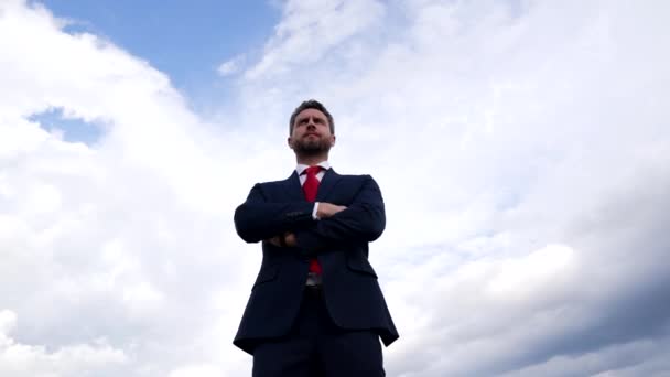 successful confident man in businesslike suit crossed hands on sky background, business success - Footage, Video