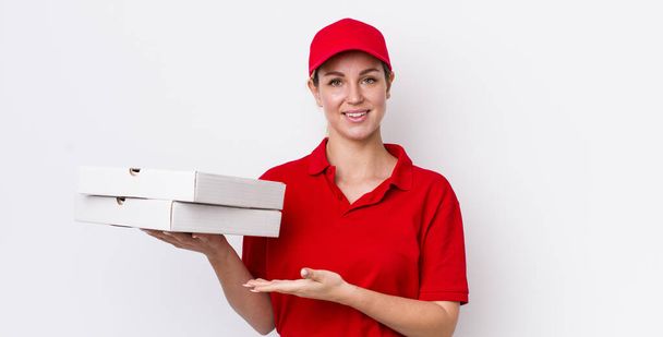 blonde pretty woman smiling cheerfully, feeling happy and showing a concept. pizza delivery concept - Foto, Bild