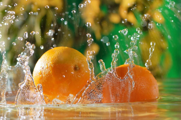 Fruits of orange fall in water with drops of water. Orange fruits are water in the nature. - Foto, immagini
