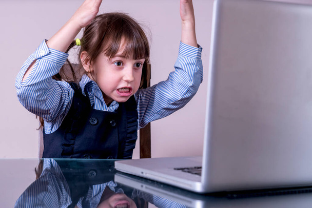 Très en colère jeune fille assise devant l'écran d'ordinateur portable  - Photo, image