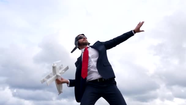 επιχειρηματίας ιδέα εκτόξευσης με αεροπλάνο στο χέρι στο φόντο του ουρανού, όνειρα - Πλάνα, βίντεο