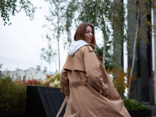 Beautiful woman in beautiful beige coat walk in autumn cloudy Moscow, Lenin's Library. Street style. Travel to Russia concept. - Foto, afbeelding