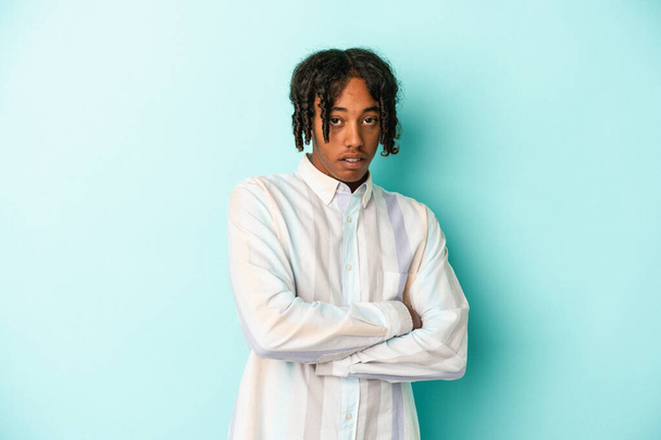 Young african american man isolated on blue background who is bored, fatigued and need a relax day. - Photo, Image