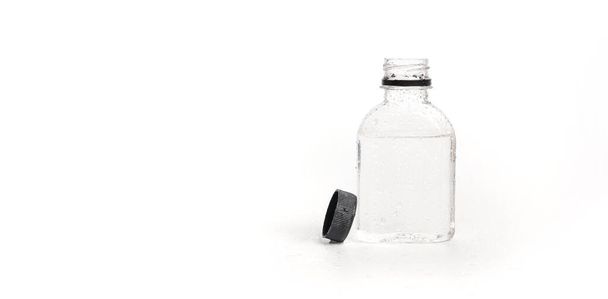kleine plastic waterfles met waterdruppels en open deksel op witte achtergrond. Plastic waterflessen voor verpakkingswater. zoet schoon water, versheid - Foto, afbeelding