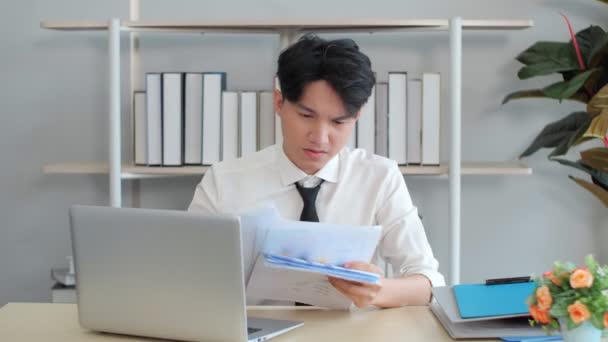 Asiático empresario sentado oficina trabajador silla y vomitar papeles hasta sentirse infeliz. Concepto de personas y problemas. - Imágenes, Vídeo