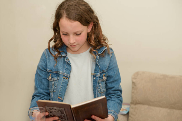 Giovane adolescente bambino libro di lettura. Bella ragazza ebrea caucasica legge Pesach Haggadah durante Seder Pasqua in casa. - Foto, immagini