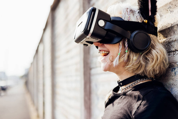 Portrait young nonconformist natural beauty woman outdoor laughing having fun using 3D goggles enjoying social media metaverse gaming online - Photo, Image