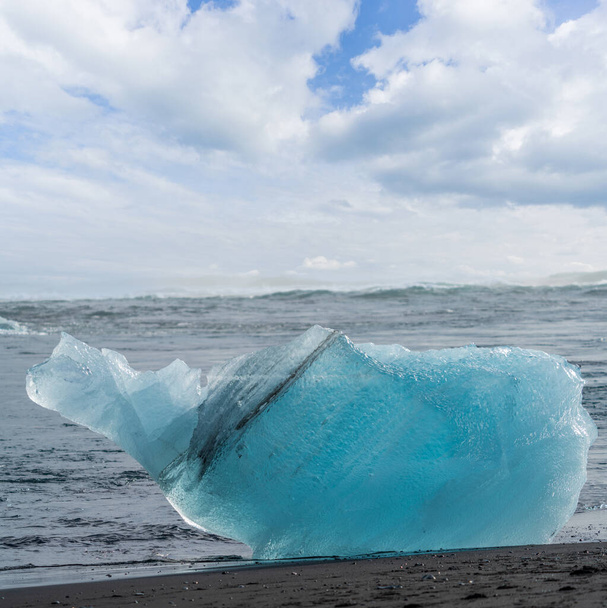 Jäävuori mustan hiekkarannan yllä, Jokulsarlon - Valokuva, kuva