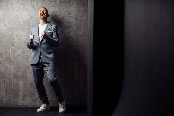 Full length body size photo of happy dancing at party man laughing in grey classic suit relaxing on holiday - 写真・画像