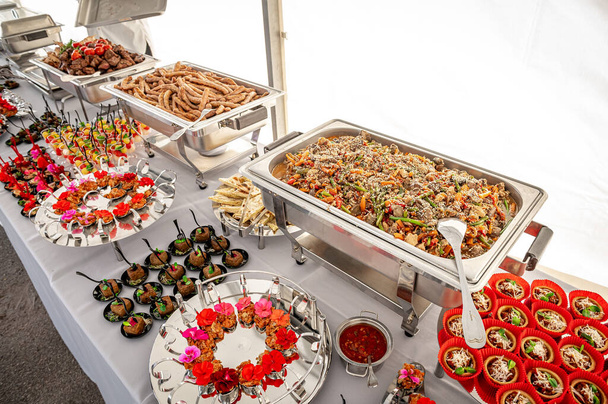 Банкетный стол с обогревателями. шведский стол с горячими блюдами - Фото, изображение