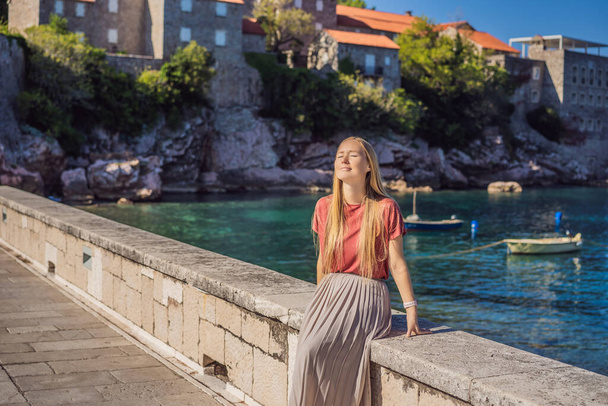 Woman tourist on background of beautiful view of the island of St. Stephen, Sveti Stefan on the Budva Riviera, Budva, Montenegro. Travel to Montenegro concept - Φωτογραφία, εικόνα