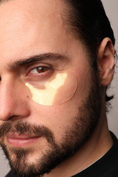 Cropped close-up portrait of bearded man wearing eye patches isolated. Vertical. - Zdjęcie, obraz