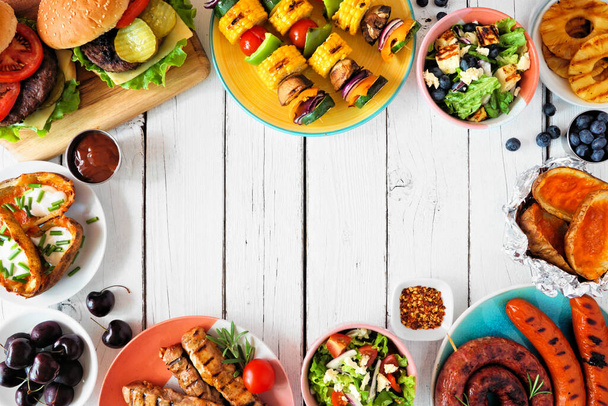 Summer BBQ or picnic food frame. Burgers, grilled meat, vegetables, fruits, salad and potatoes. Top view on a white wood background. Copy space. - Φωτογραφία, εικόνα