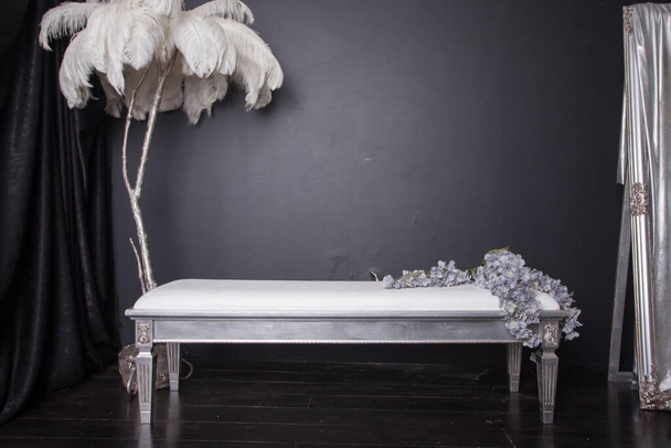 White bench in studio decorated with flowers, stylish interior  - Photo, Image
