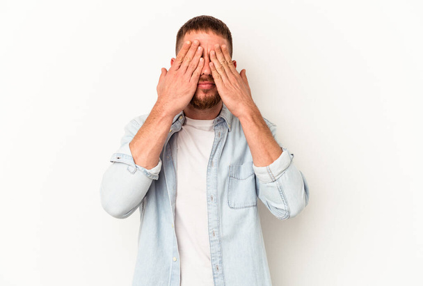 Young caucasian man with diastema isolated on white background afraid covering eyes with hands. - 写真・画像