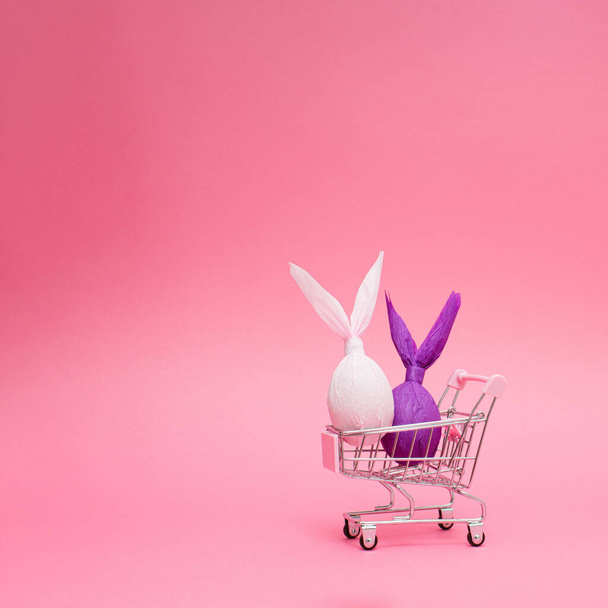 Coniglietti pasquali in un carrello della spesa. Divertente concetto di vacanza di Pasqua. - Foto, immagini