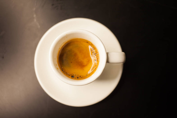 Freshly made coffee served in a cup on a dark background - Photo, Image
