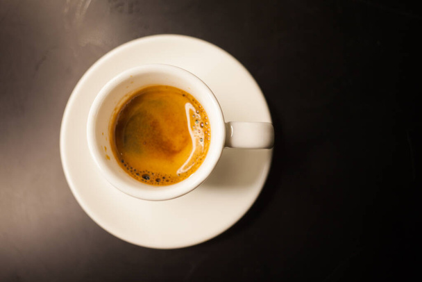 Freshly made coffee served in a cup on a dark background - Foto, Imagem
