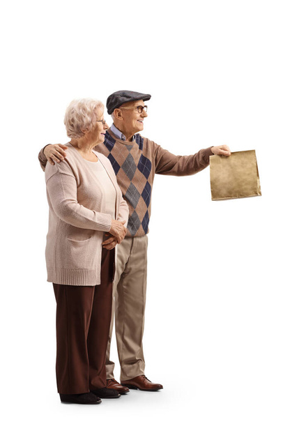 Elderly man and woman handing a paper bag isolated on white background - Foto, afbeelding