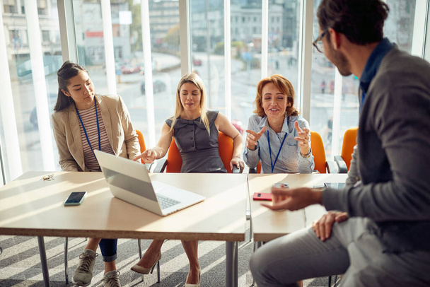 A group of young business people in commission is chatting in a relaxed atmosphere during a break of an interview for a new job position. Business, people, company - Foto, imagen