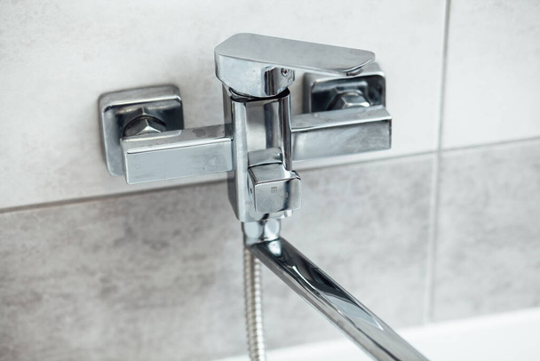 Modern fürdőszoba mosdó króm csapvízzel és szürke csempe - Fotó, kép