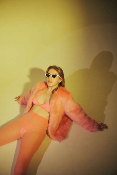 Modelo de moda en traje rosa y gafas de sol. Grabado en estudio. Edición de película - Foto, imagen