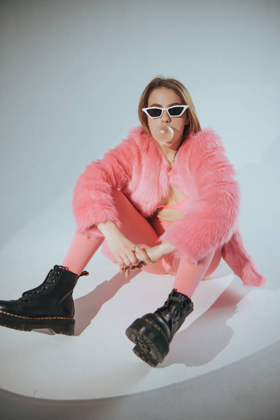 Fashion model in pink suit and sunglasses. Studio shot. Film edit - Photo, Image