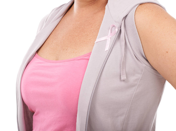 Showing her support. Mature woman wearing a breast cancer awareness ribbon against a white background. - Fotografie, Obrázek